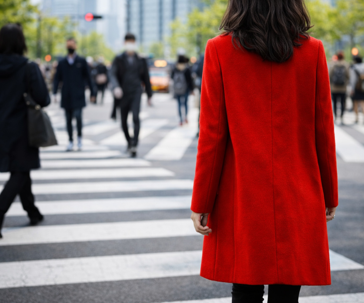 明るい街並みの中で赤いコートを着た女性が歩く春のファッションシーン