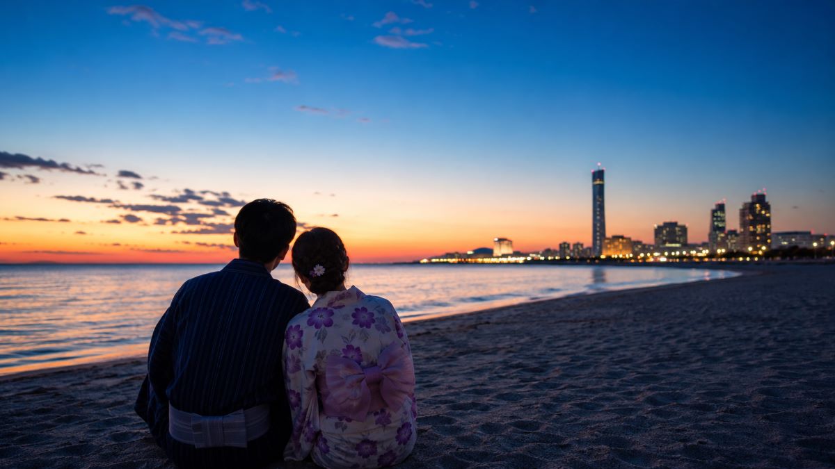 夕暮れの幕張ビーチで浴衣姿のカップルが静かな海と夏の始まりを見つめている風景
