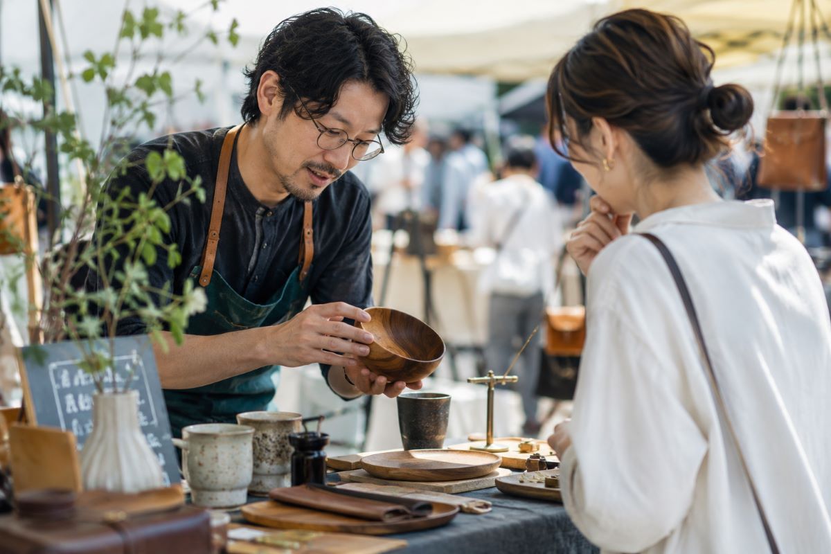 作家と来場者が木の器について対話しながら、一生モノの価値を見極めているマルシェ風景
