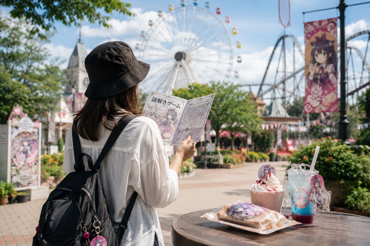 遊園地で謎解き冊子を手にしながら限定フードを楽しみ、世界観に没頭する来園者の後ろ姿