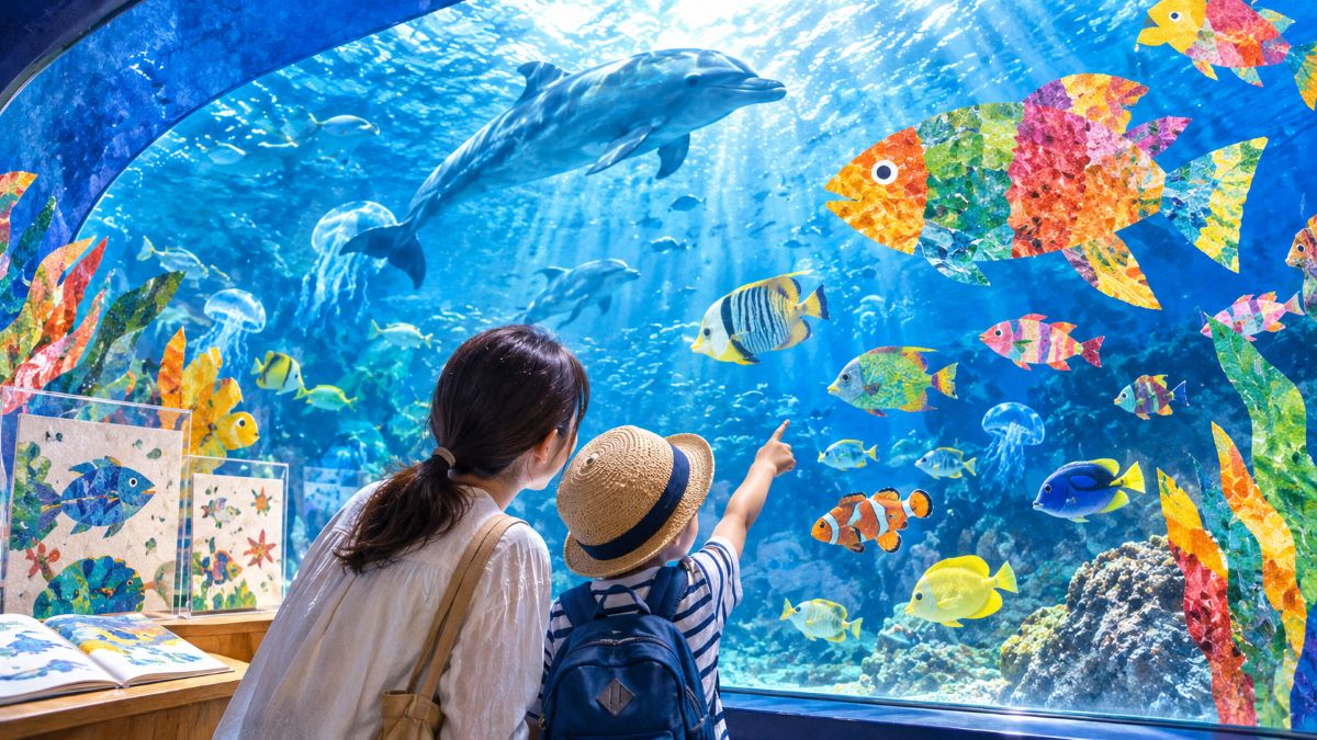 しながわ水族館の大水槽で親子がコラージュ風の魚と本物の海の生き物を眺める幻想的な展示
